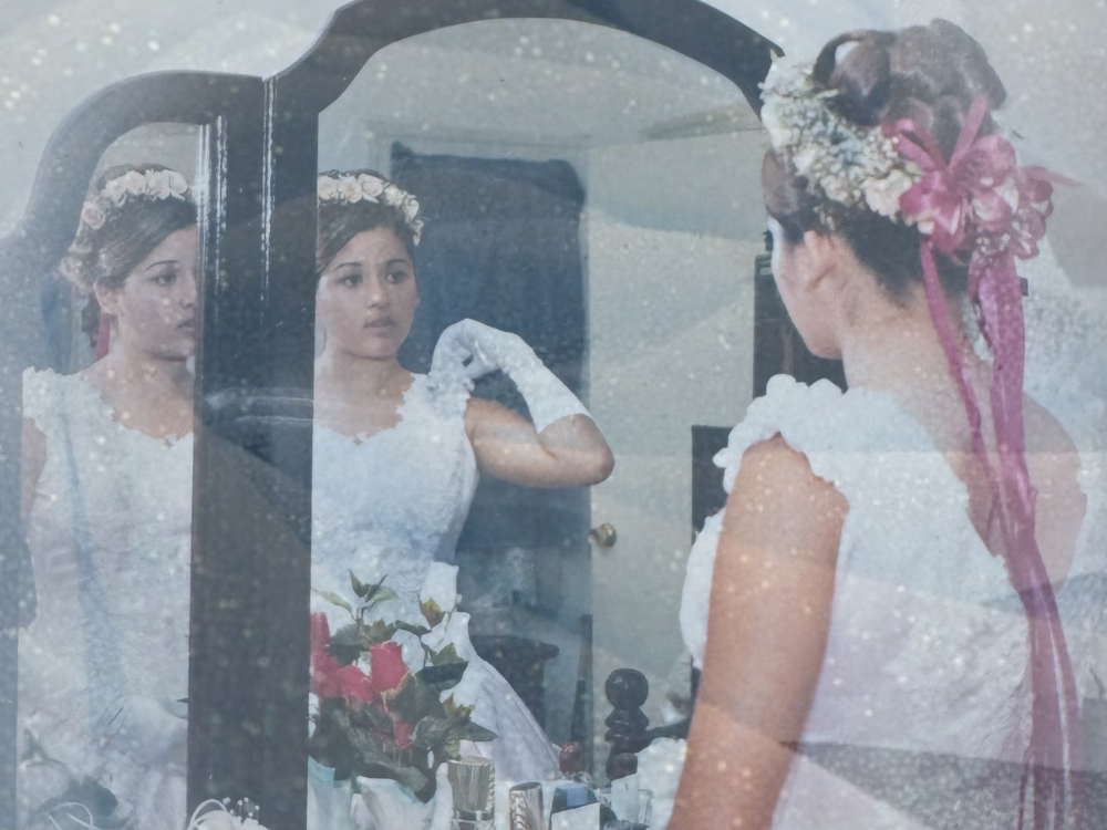 a photograph of a young girl looking at herself in the mirror with a sparkly blue effect on top